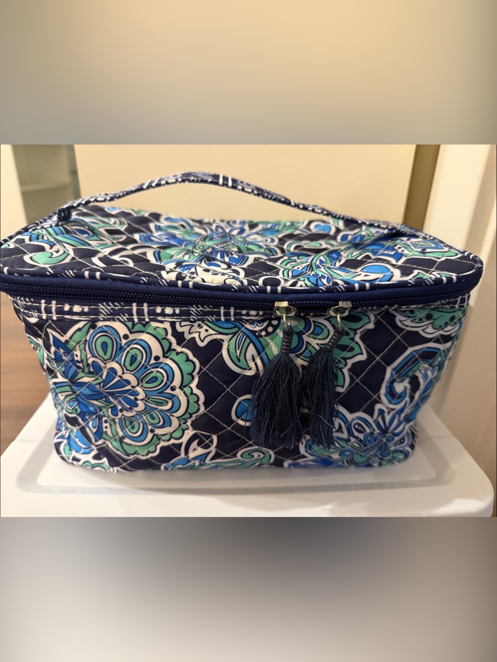 Blue makeup bag with tassel zippers.